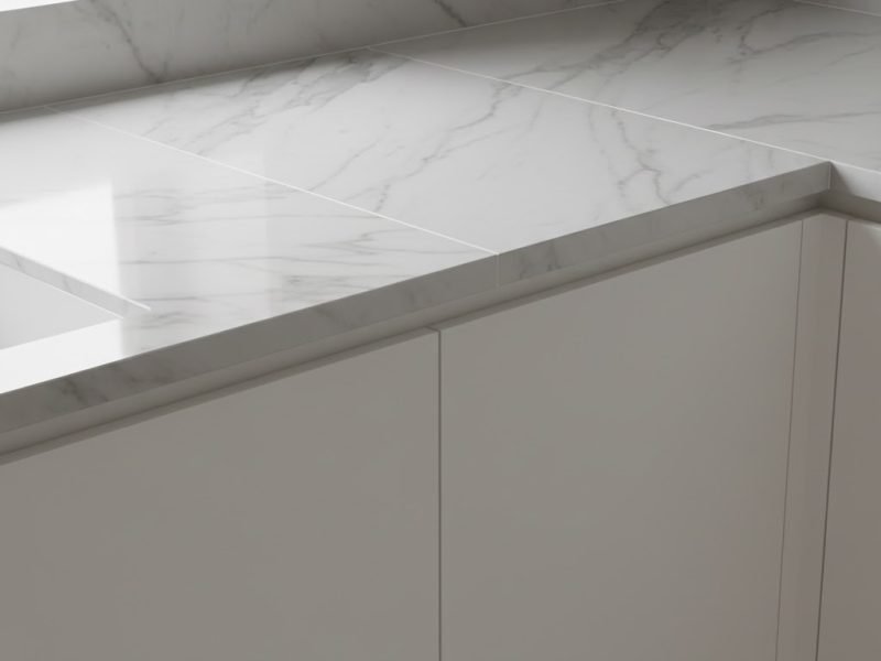 Detail meja dapur minimalis dengan keramik motif marble putih yang terlihat rapi dan elegan dalam pencahayaan alami lembut