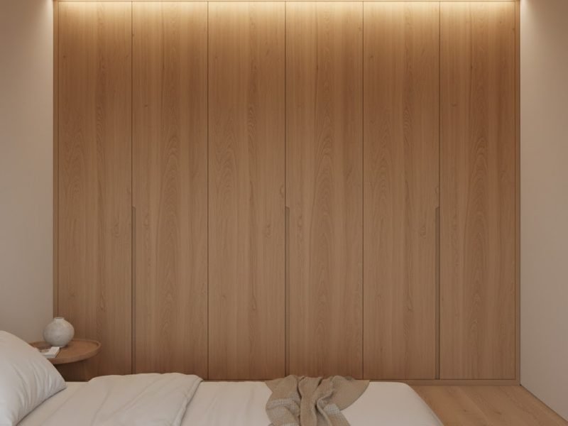 Lemari pakaian kayu built-in dengan finishing natural yang menyatu elegan dengan kamar tidur minimalis modern